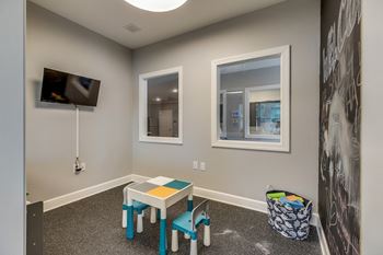 an activity room with a table and chairs and a television